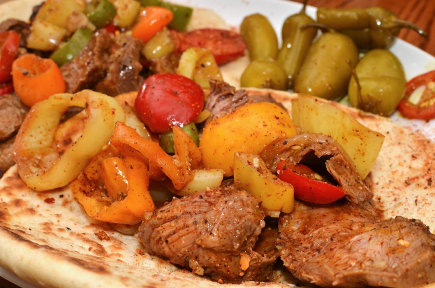 Teller mit Tomaten, Chilischoten und Stückchen von gekochtem Huhn