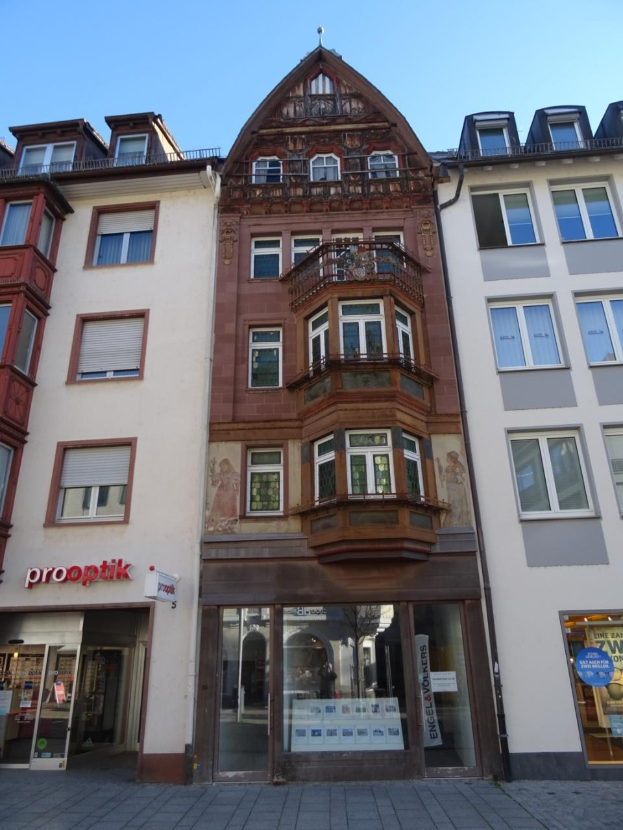Gewerbegrundstück mit vielen Fenstern zum Verkauf an einer Straße in Heidelberg, Deutschland, unter einem klaren blauen Himmel.
