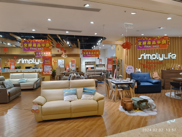 Innenansicht eines Möbelgeschäfts in China mit Sofas, Tischen, Stühlen, Hockern und anderen Gegenständen sowie Deckenlampen und Informationsschildern.