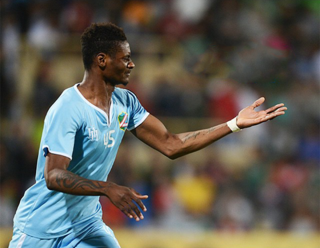 Ein Fußballspieler in einem blauen Trikot feiert mit ausgestreckten Armen nach einem Tor