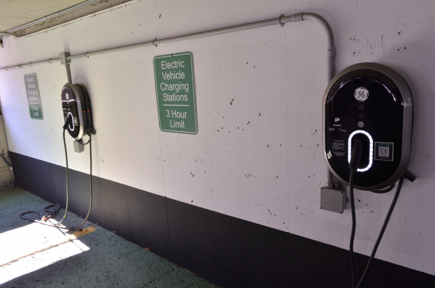 Zwei Ladestationen für Elektrofahrzeuge an einer Wand in einer Tiefgarage mit Informationsschildern und sichtbarer Bodenfläche.