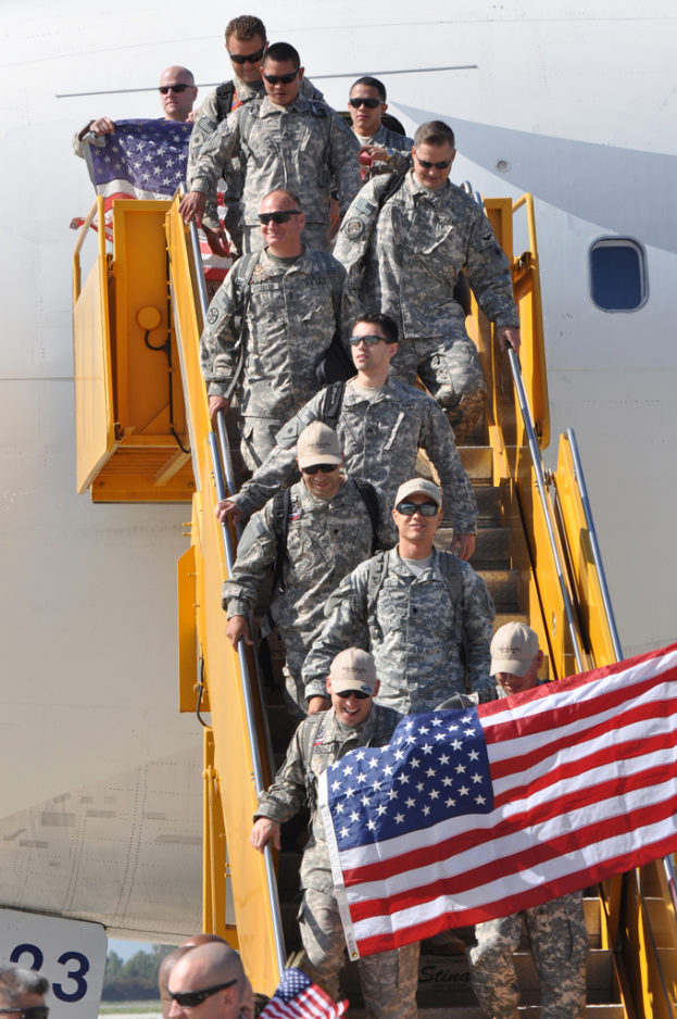 Ein Flug mit Treppe, voll mit Menschen, einige tragen Mützen und Schutzbrillen, mit Flaggen und einer Zahl unten.