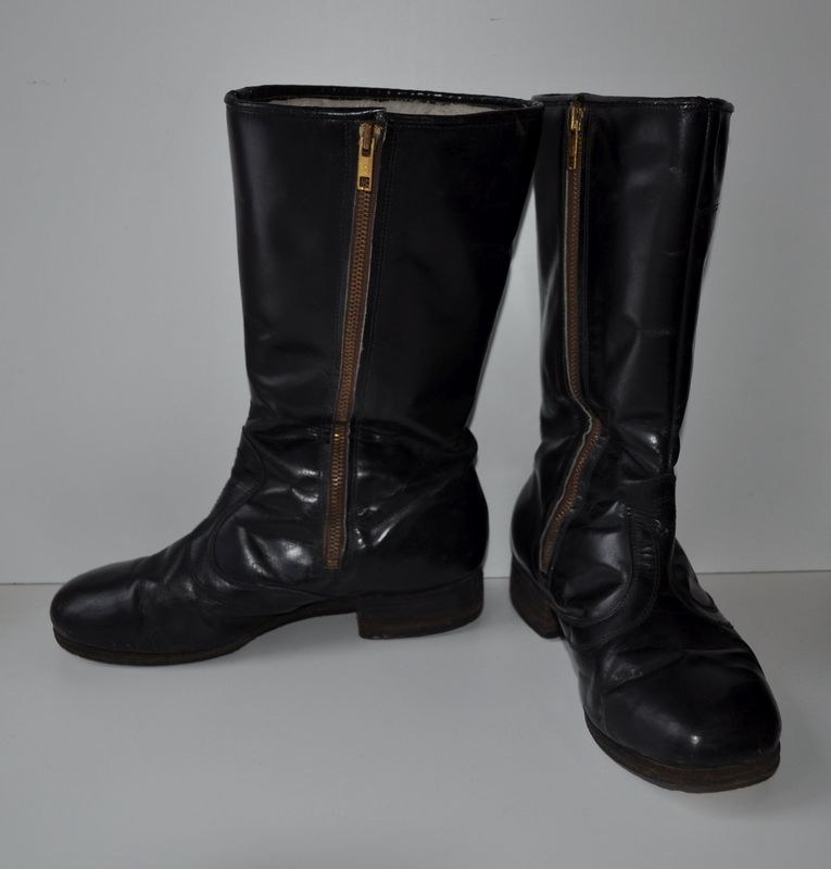 Schwarze Lederstiefel mit silbernen Reißverschlüssen auf einem weißen Hintergrund, mit einem glatten, glänzenden Finish.