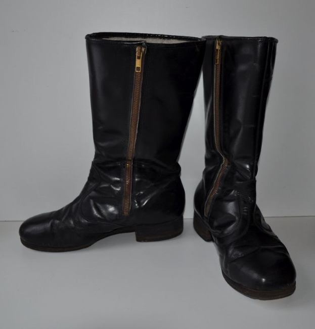 Schwarze Lederstiefel mit silbernen Reißverschlüssen auf einem weißen Hintergrund, mit einem glatten, glänzenden Finish.