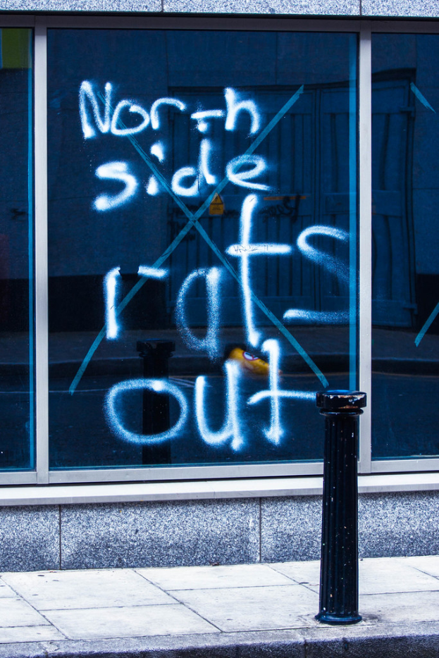 Text auf einem Fenster und einem Absperrpfahl auf der Straße.