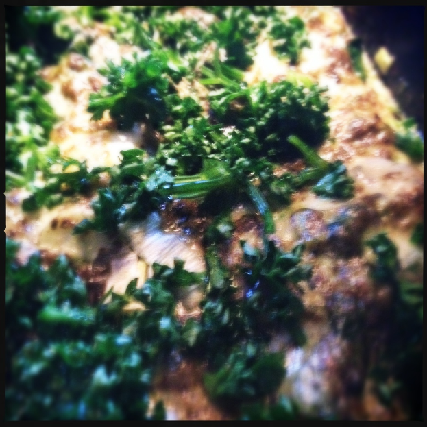 Ein Tablett mit Pizza und grünen Gemüsen.