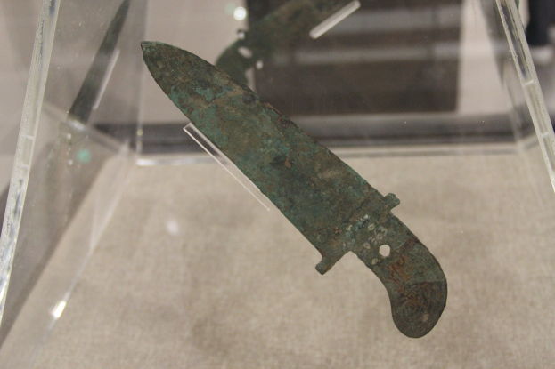 Ein Messer in einer durchsichtigen Glasvitrine mit sichtbaren detaillierten Klingendetails.
