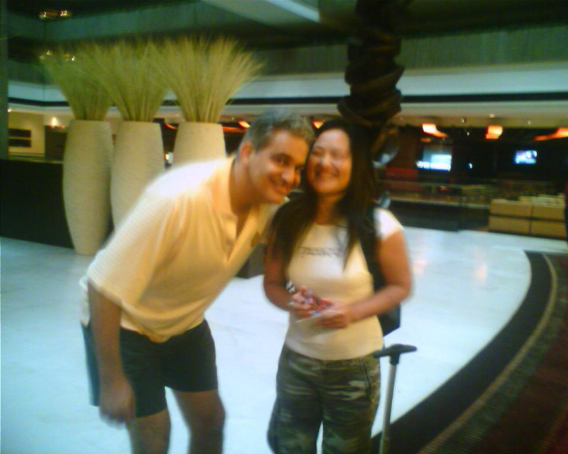 Ein Mann und eine Frau, die vor Sofasesseln stehen und lächeln.