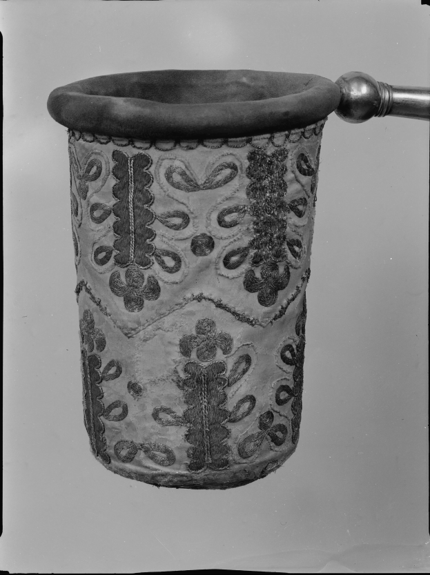 Ein Schwarz-Weiß-Foto eines Stoff-Abfallkorbs mit Griff.