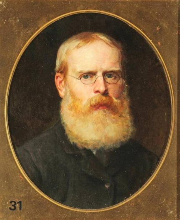 Porträt eines bärtigen Mannes in einem weißen Hemd und dunklen Hosen, der mit gefalteten Händen dasitzt, eine Brille trägt und einen ernsten Gesichtsausdruck hat, gerahmt mit Zahlen auf der linken Seite.