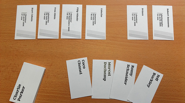 Ein hölzerner Tisch mit mehreren weißen Visitenkarten mit gedrucktem Text.
