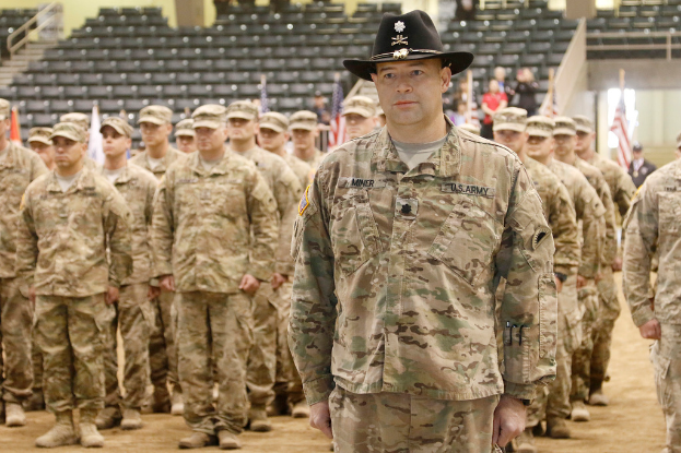 Soldaten im Vordergrund, Fahnen und Menschen in der Mitte, mit Sitzplätzen, Treppe, Geländer und anderen Objekten im Hintergrund.