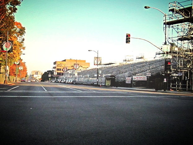 Eine Straße mit einer Ampel und Equipment auf der rechten Seite, Warnschilder und mehrere Fahrzeuge auf der linken Seite und Bäume im Hintergrund.