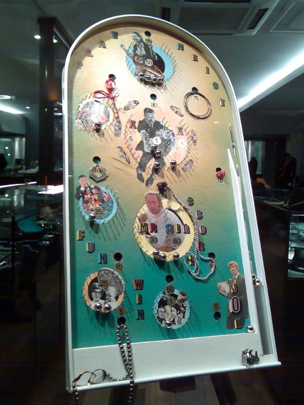 Ein Flipperautomat im Vordergrund mit einer Decke und einer zentralen Klimaanlage auf dem Dach im Hintergrund.