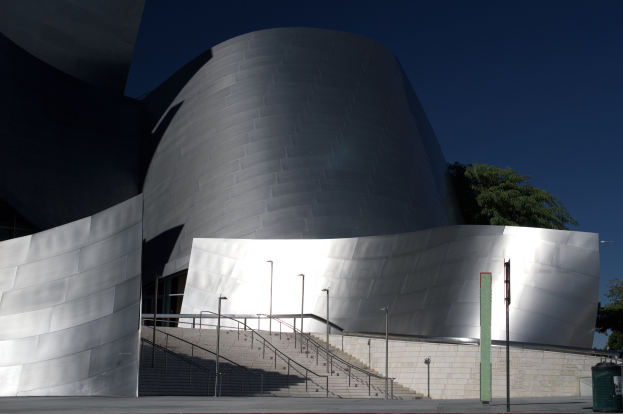 Das ARTIST Concert Hall in Los Angeles, ein großes Gebäude mit einer Treppe, die zum Eingang führt, umgeben von Straßenmasten, Bäumen und einem Mülleimer, unter einem bewölkten Himmel.