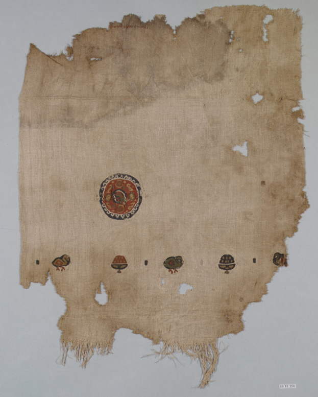 Ein Stoffstück mit einem kreisförmigen Design, das lebhafte, detaillierte Formen wie Kreise, Quadrate und Dreiecke gegen einen weißen Hintergrund zeigt.