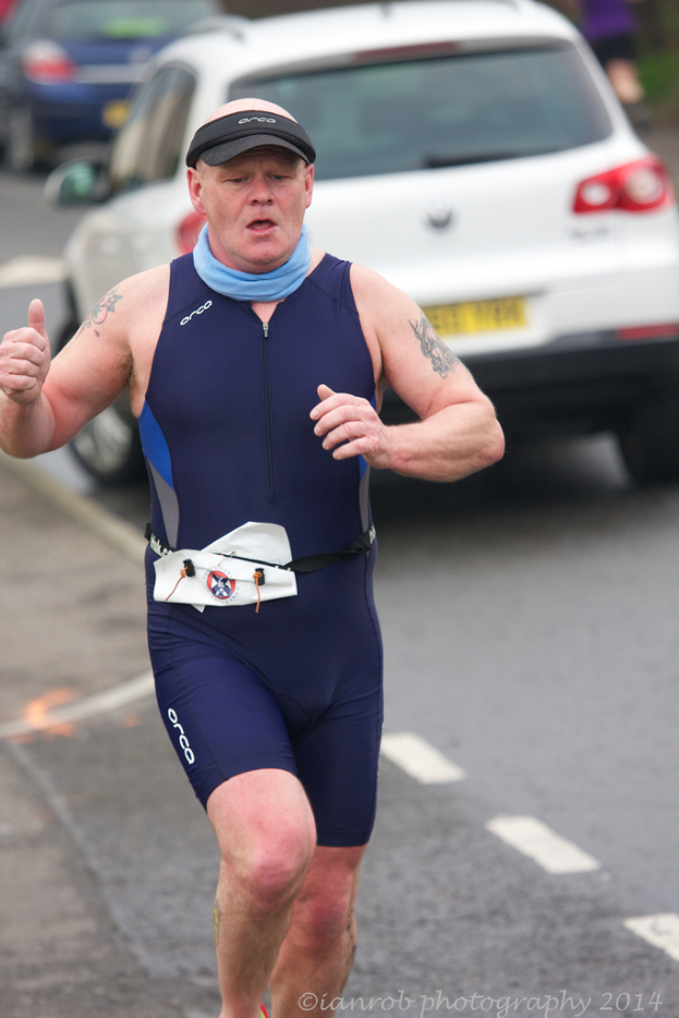 Ein Mann läuft auf der linken Seite des Bildes mit Autos im Hintergrund.