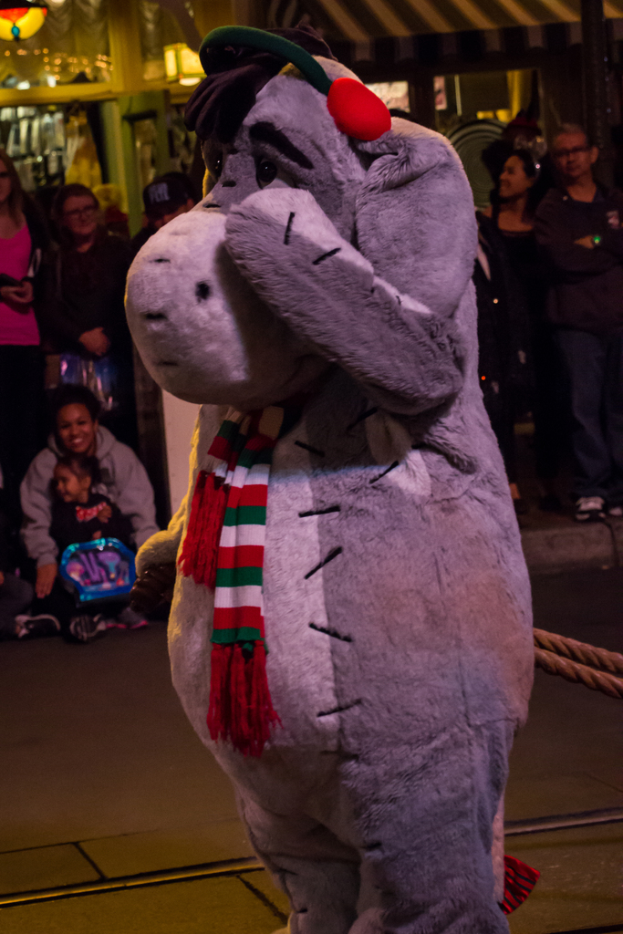 Eine Person in einem Tierkostüm steht zwischen einer Menschenmenge, mit sichtbaren Lichtern auf dem Dach.