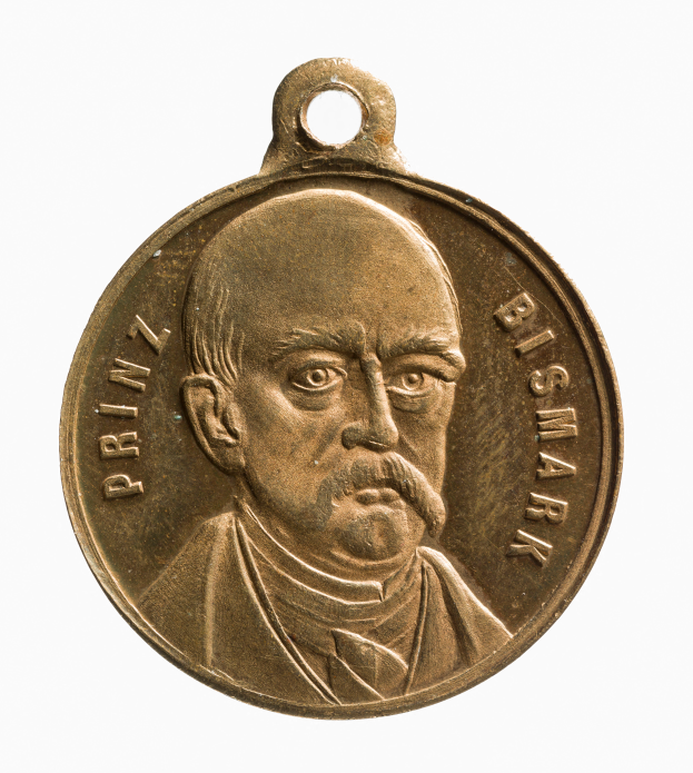 Eine goldene Medaille mit einem Porträt eines Schnauzbärtigen, der mit "Bismarck-Preis" beschriftet ist, vor einem weißen Hintergrund.