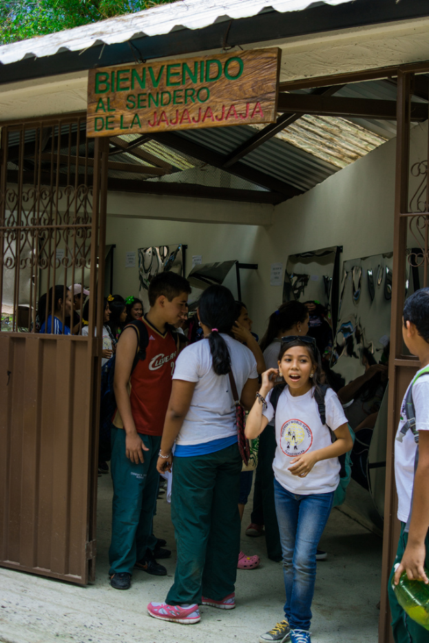 Ein Geschäft mit einer Eisenblechfassade und einem Schild mit Text oben drauf, mit Menschen drinnen.