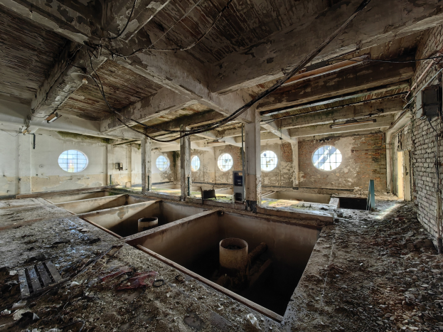 Verlassenes Gebäudeinnere im Chernobyl-Ausschlussgebiet mit verstreuten Trümmern, sichtbaren Wänden, Decke und strukturellen Elementen.