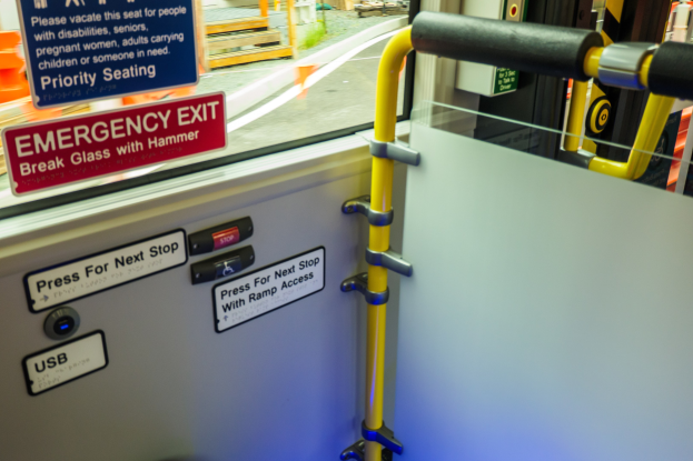 Notausgangsschild an der Seite eines Zuges mit einer TГјr, Griff und Glasfenster.