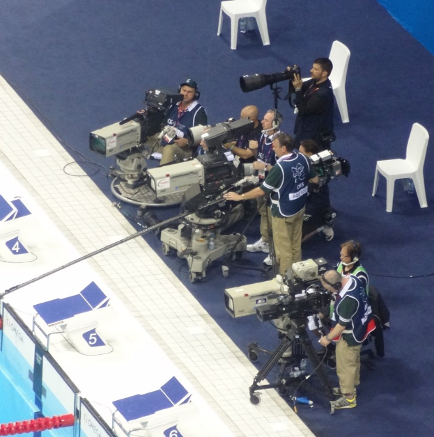 Eine Gruppe von Menschen mit Kameras, mit mehreren Stühlen im Hintergrund.