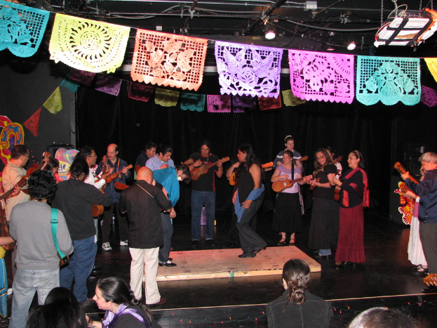 Menschen mit Instrumenten im Zentrum, mit Dekorationen und Lichtern oben und einem Boden unten.