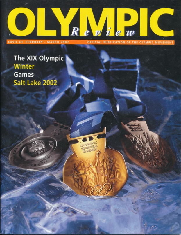 Ein Buch mit dem Titel "Olympische Revue" mit mehreren Medaillen in verschiedenen Größen und Farben und fett gedrucktem Text auf dem Cover.