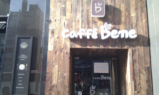 Ein Geschäft mit der Aufschrift "CAFFE BENES", einer schwarzen Tür und einer Glastür.