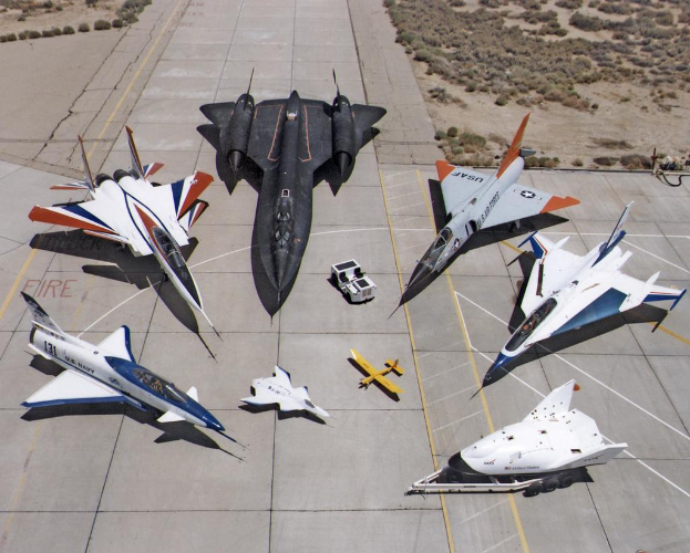 Ein Jet-Flug ist in der Mitte des Bildes zu sehen, mit einer Landebahn darunter und Büschen im Hintergrund.